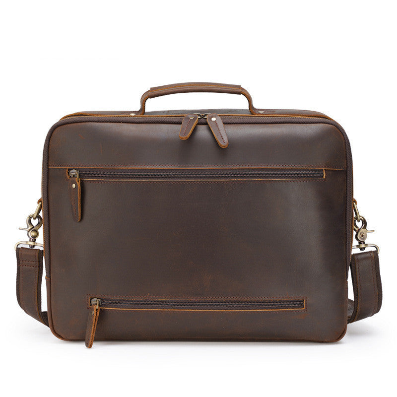 Brown leather briefcase with shoulder strap on a white background
