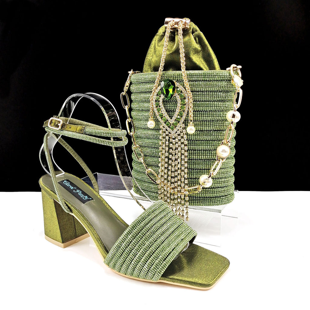 Green high-heeled shoe and matching handbag with decorative elements on a white background