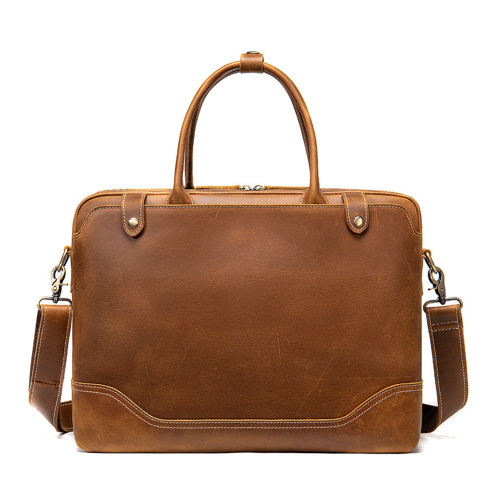 Brown leather briefcase with shoulder strap on a white background