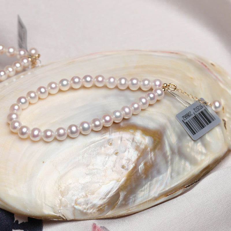 Pearl necklace on a shell with a visible tag