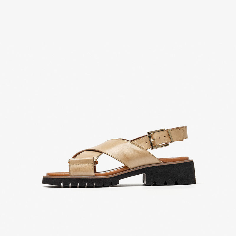 Beige sandal with a black sole on a white background