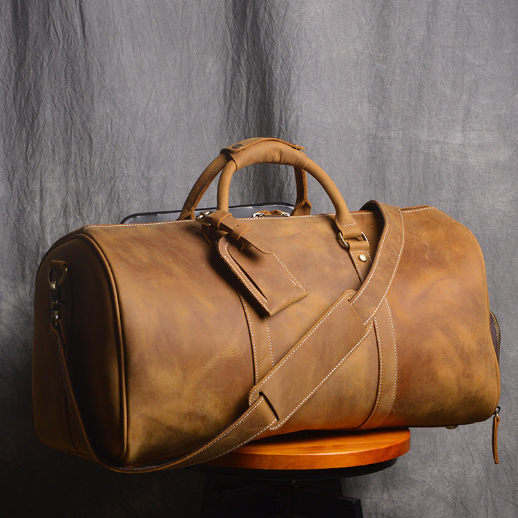 Brown leather duffel bag on a gray background
