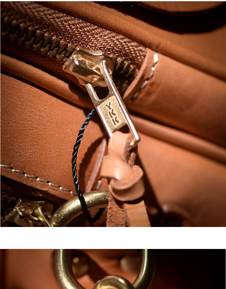 Close-up of a brown leather bag with gold zipper and clasp.