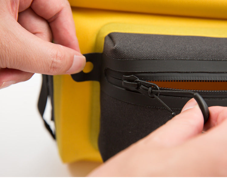 Close-up of hands zipping a yellow and black bag