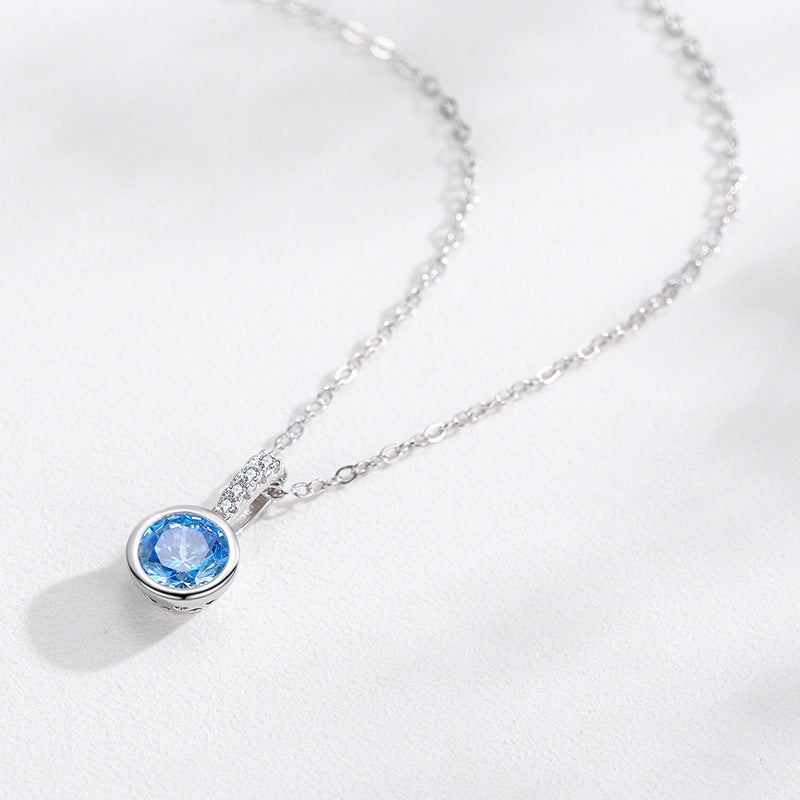 Silver necklace with a blue pendant on a white background