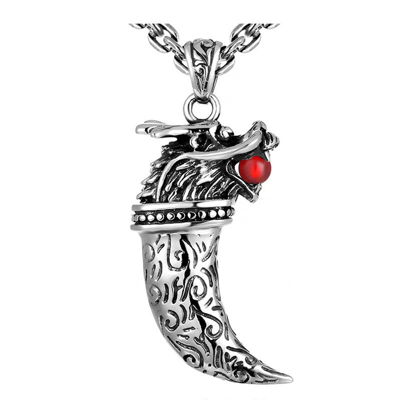 Silver dragon tooth pendant with a red gem on a white background