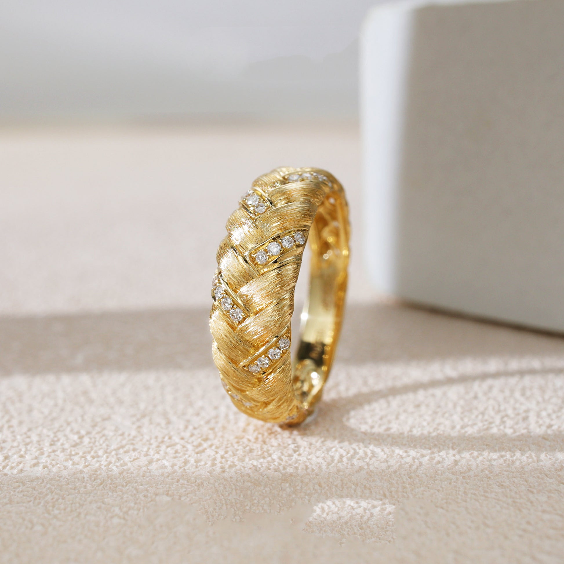 Gold ring with diamond accents on a textured surface