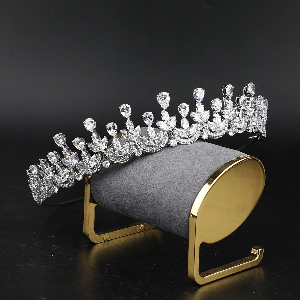 Diamanté tiara on a gold and gray stand against a black background