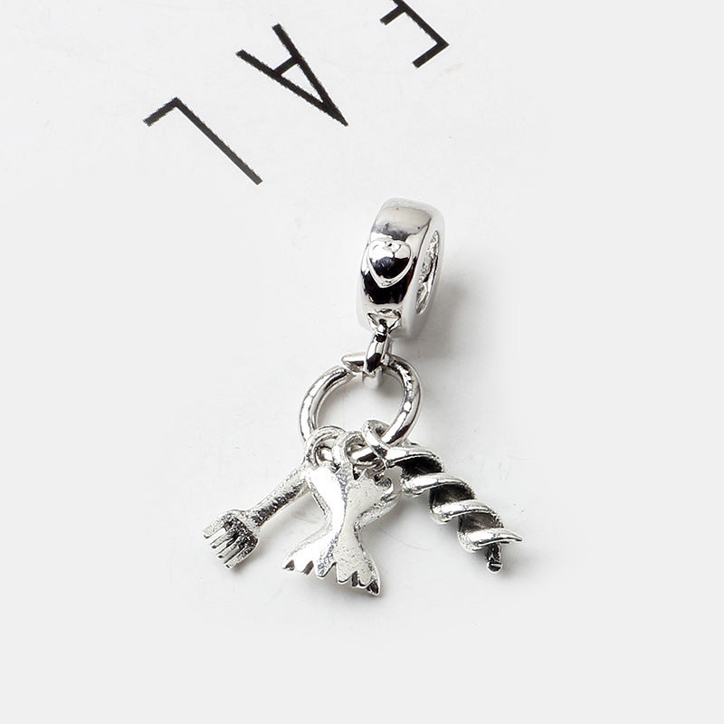 Silver pendant with a broom and scarf design on a white background