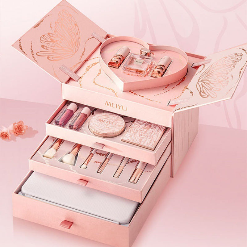 Pink makeup set with various cosmetic items on a pink background