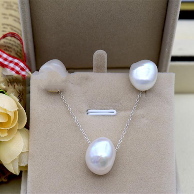 Pearl necklace and earrings set on a display card with a blurred background
