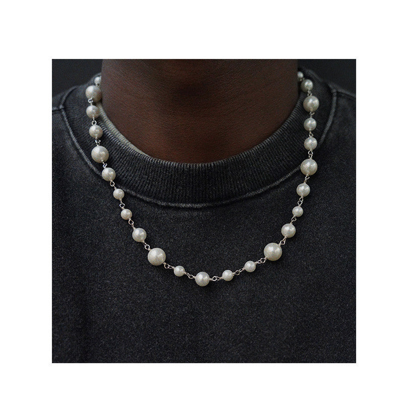Pearl necklace worn by a person on a black background