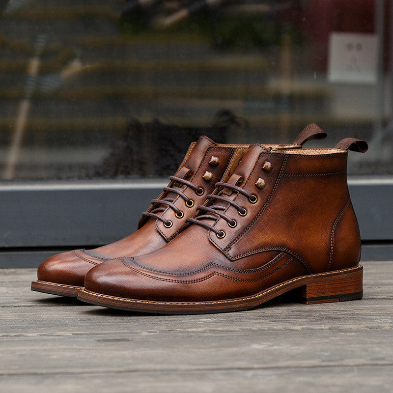 Pair of brown leather boots on a wooden surface with a blurred background