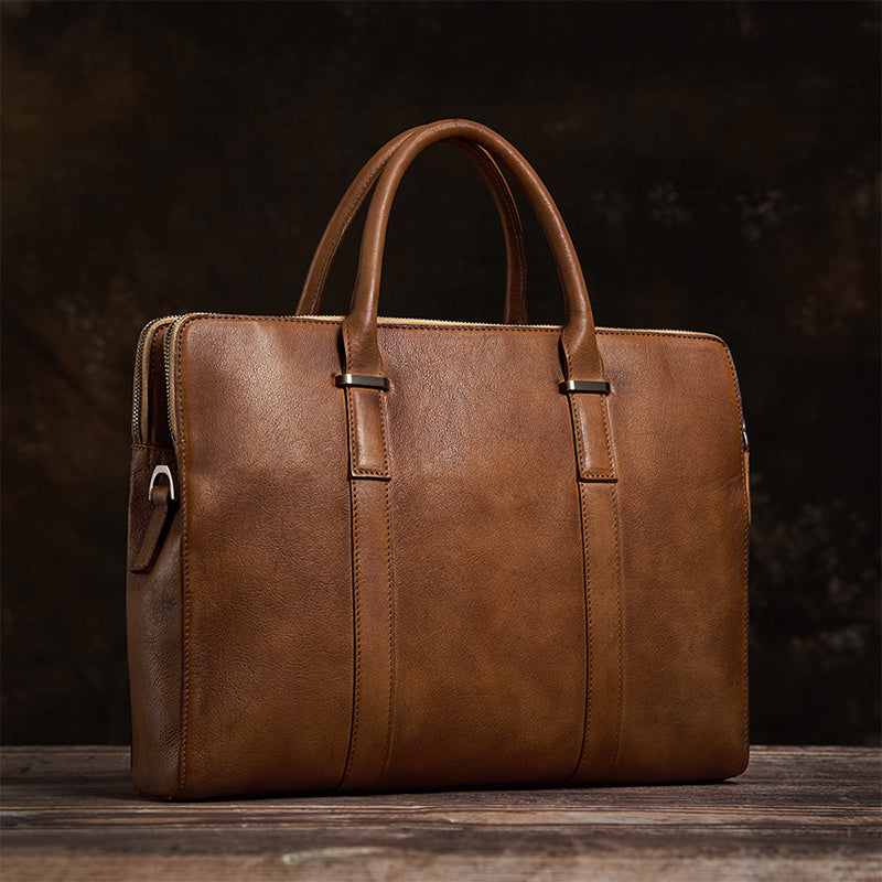 Brown leather briefcase on a wooden surface with a dark background