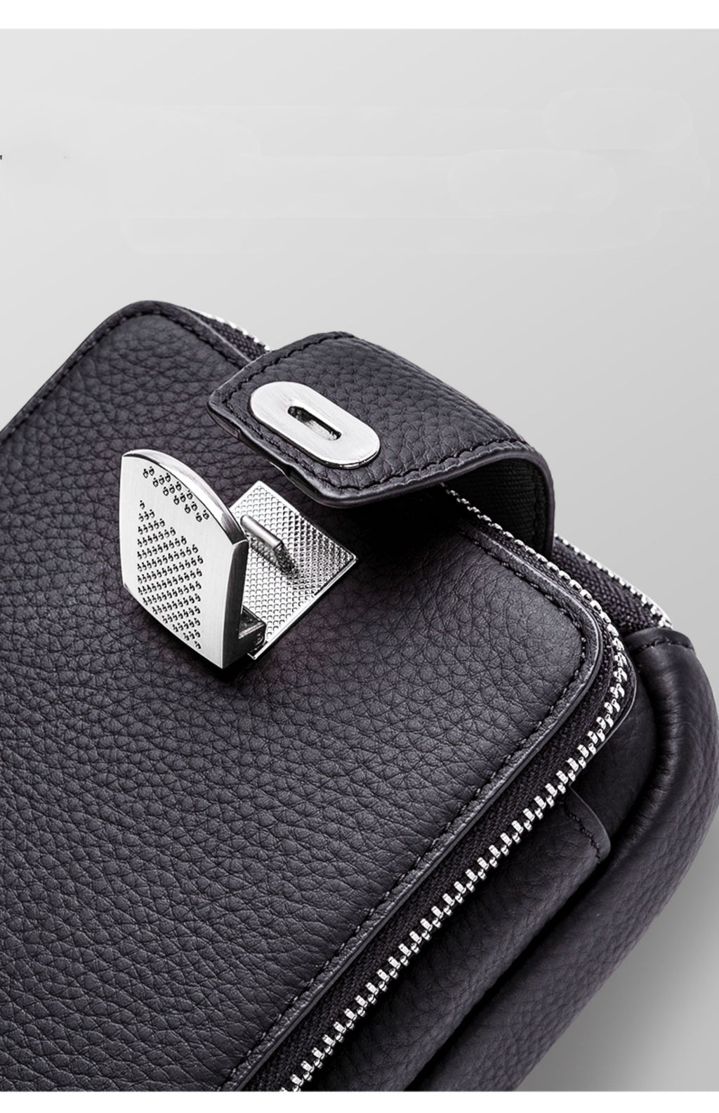 Black leather bag with silver clasp on a gray background