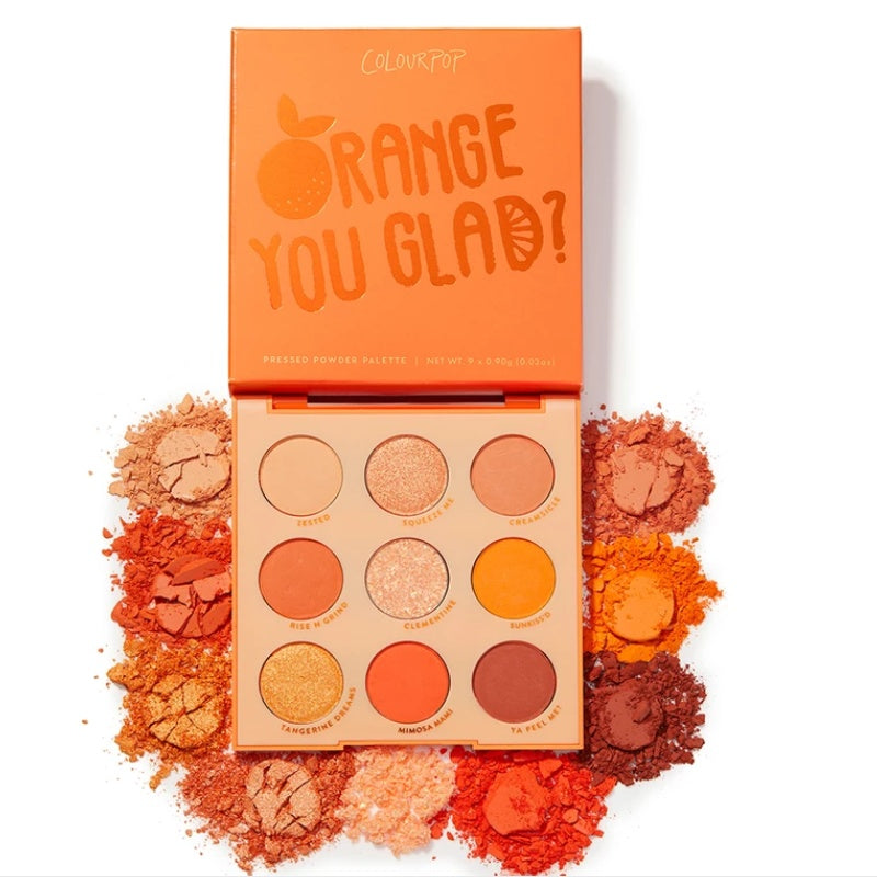 Makeup palette with orange shades and 'Orange You Glad?' text on a white background