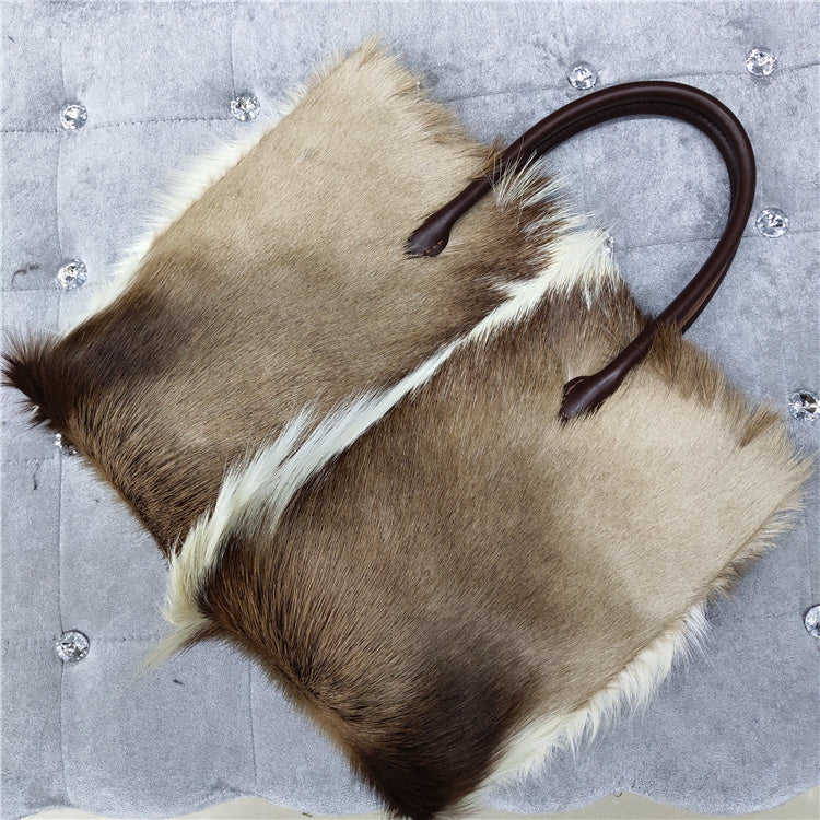 Horse hair bag with a brown handle on a textured gray background