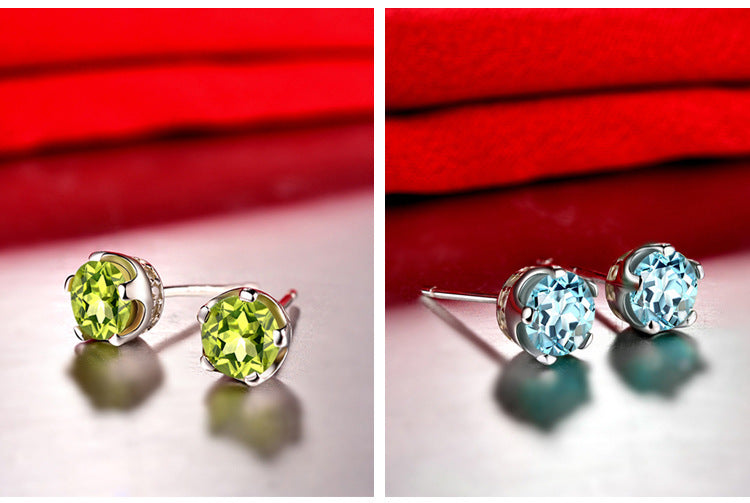Pair of green gemstone earrings on a red background