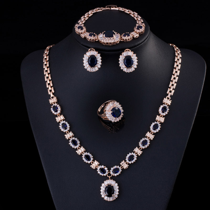 Jewelry set including necklace, earrings, and ring on a black stand