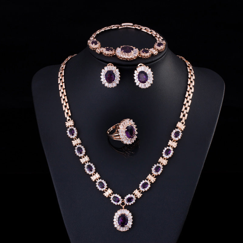 Jewelry set including necklace, earrings, and ring on a black stand with a dark background