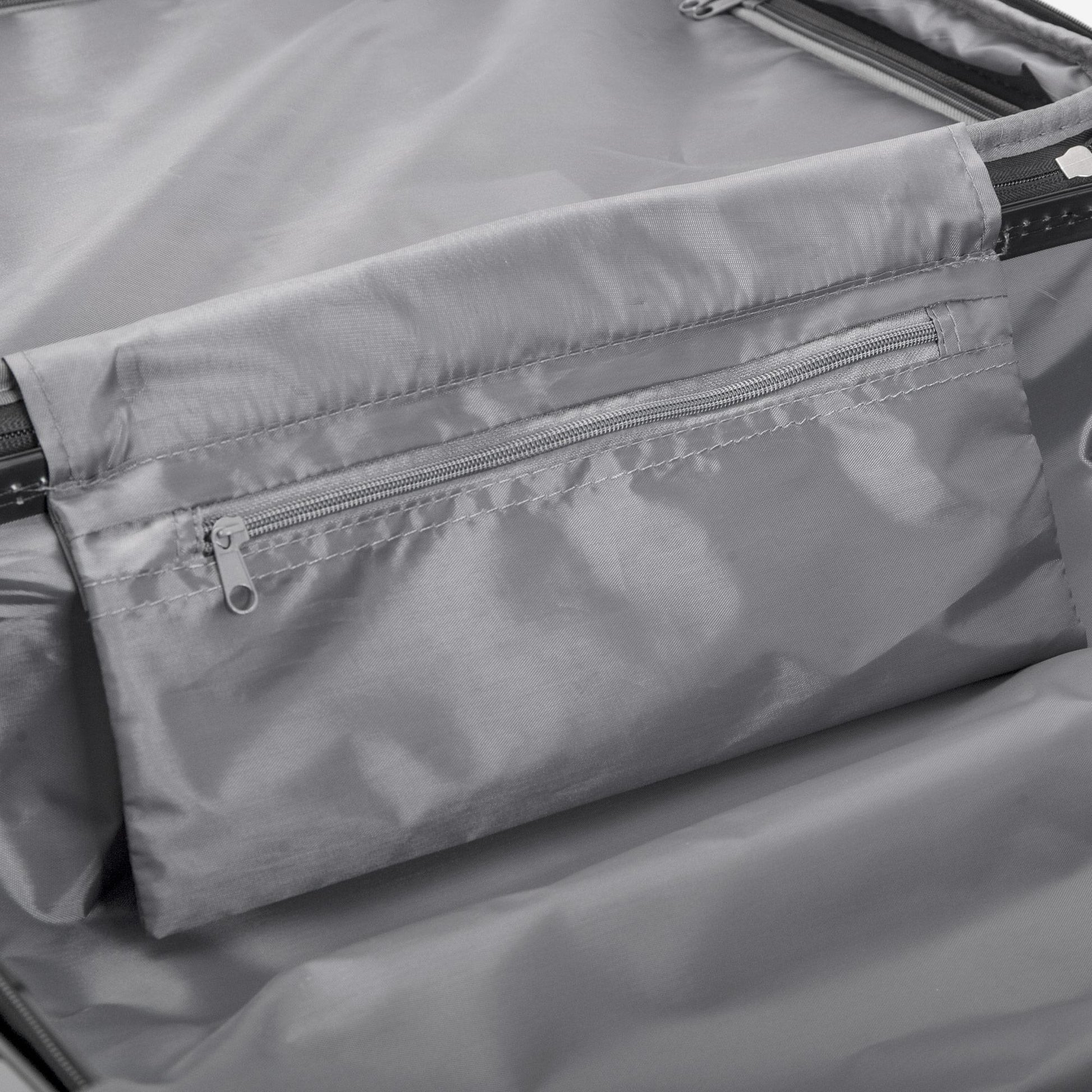 Close-up of a gray fabric with zippers on a product, likely a bag or jacket.