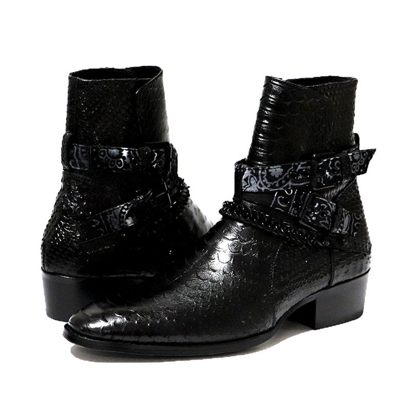 Pair of black leather boots with decorative straps on a white background