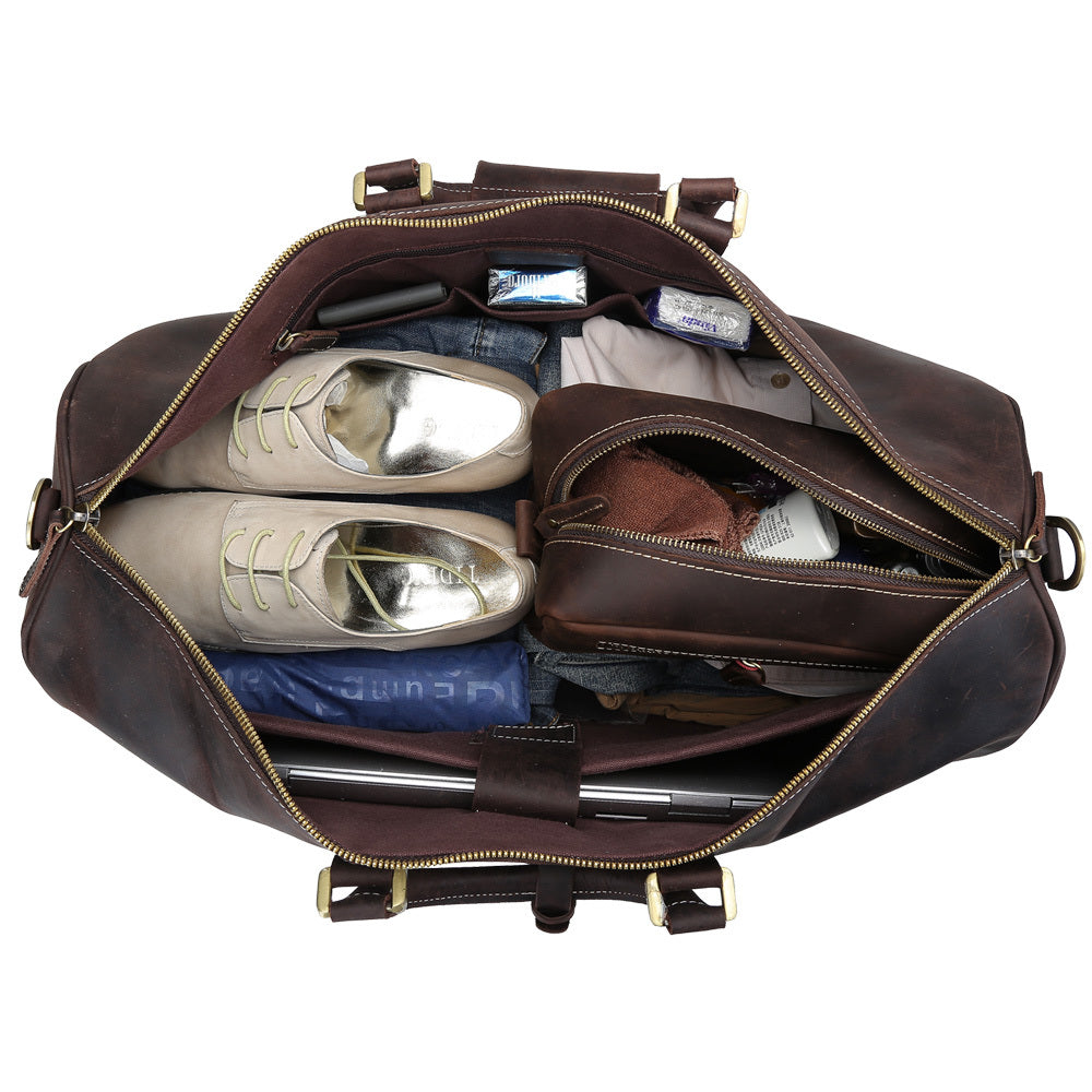 Brown leather duffel bag with shoes and clothes inside on a white background
