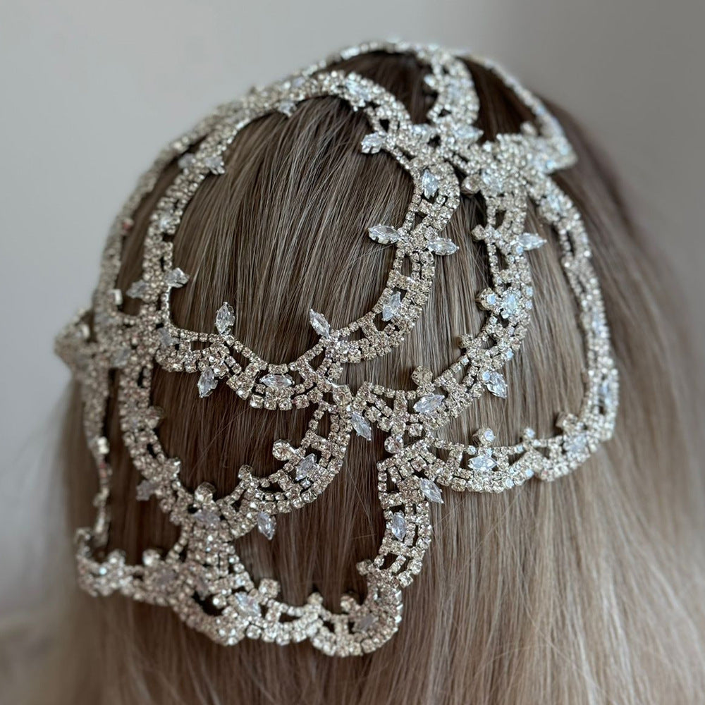Elegant silver headpiece worn by a person with brown hair against a neutral background
