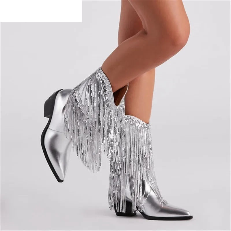 Silver fringe boots worn by a person on a light gray background