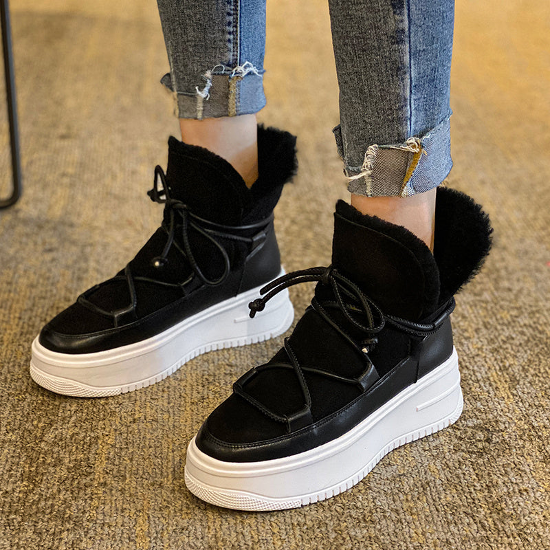 Black sneakers with white soles worn with ripped jeans on a carpeted floor.