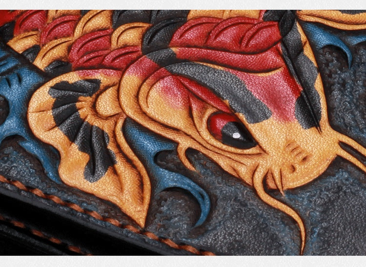 Close-up of a detailed leather dragon embossing with red, black, and gold colors.