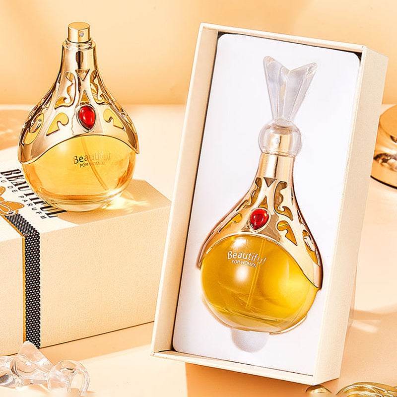 Perfume bottle with decorative design and red gemstones, displayed both on a stand and in an open box.