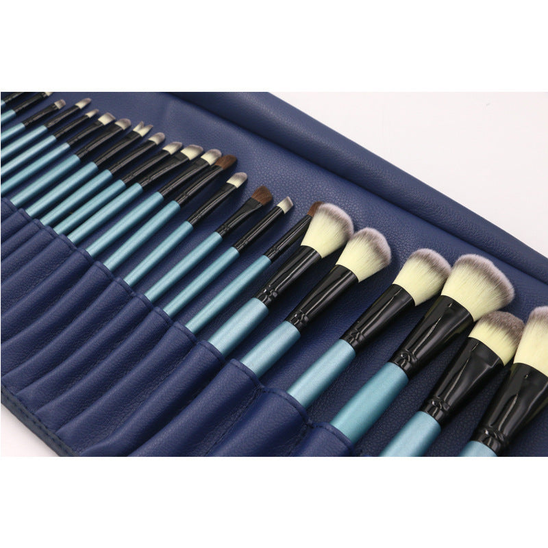 Set of makeup brushes with blue handles and black bristles in a navy case.