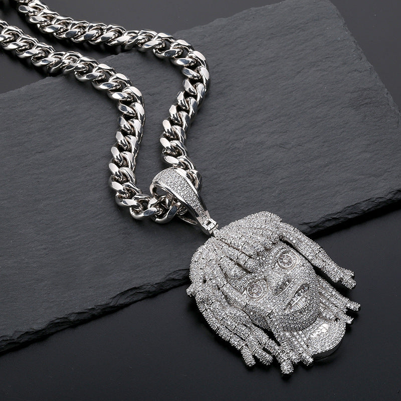 Silver chain necklace with a detailed pendant on a dark surface