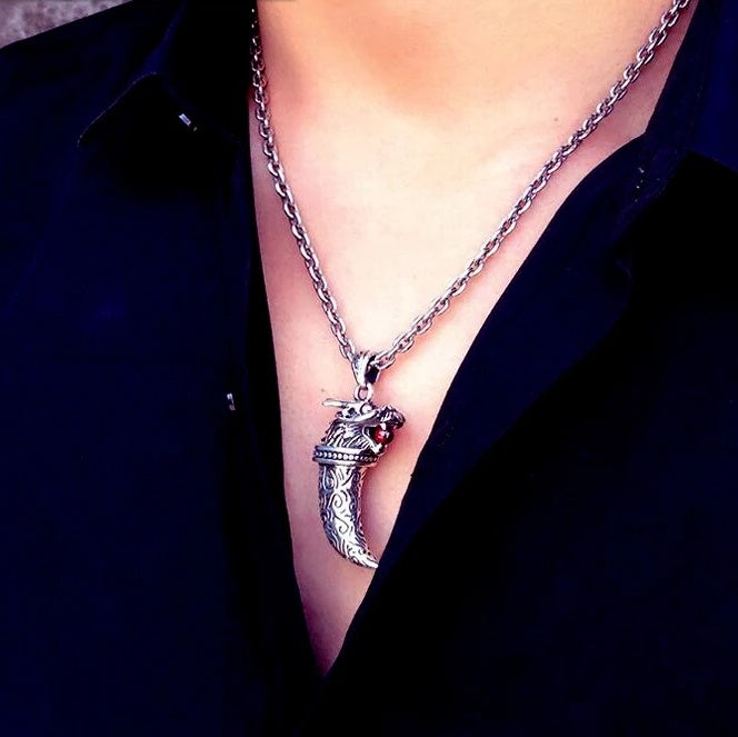 Silver necklace with a pendant worn by a person against a dark background