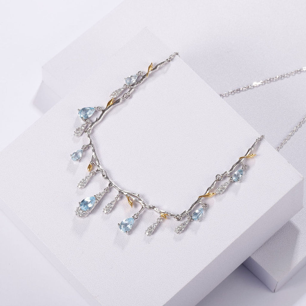 Silver necklace with blue gemstones on a white surface