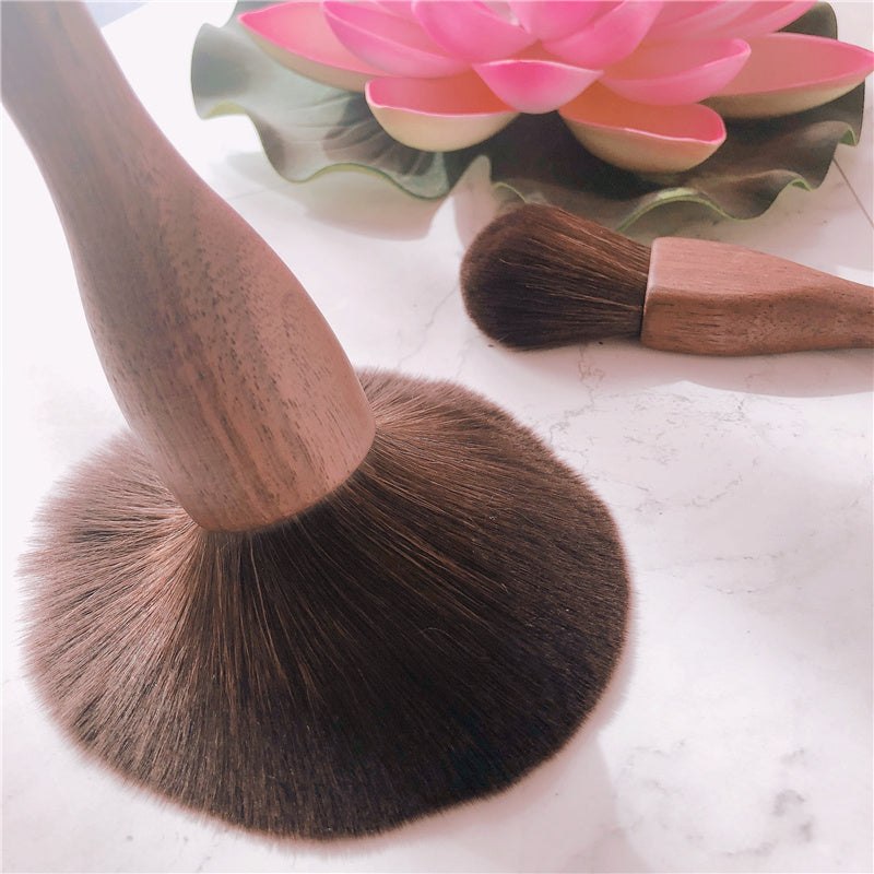 Makeup brushes with wooden handles on a light background