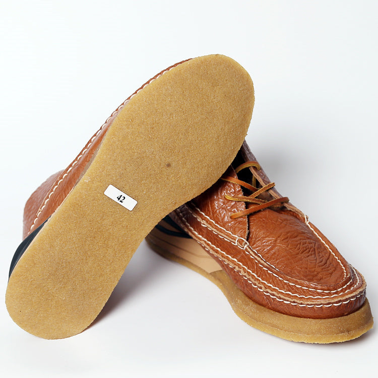 Brown leather shoe with tan sole on a white background