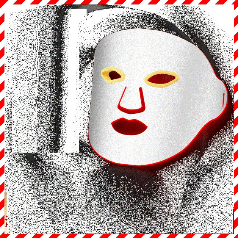 White face mask with red and yellow accents on a black and white background