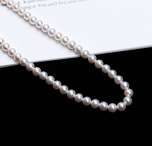 Pearl necklace on a black and white surface