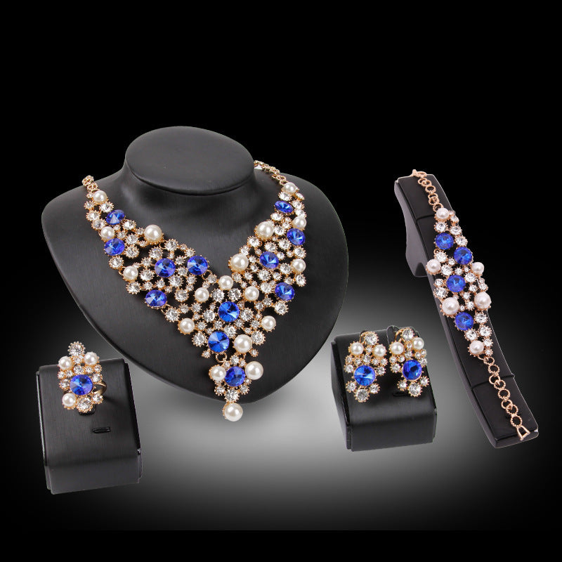 Jewelry set with necklace, earrings, and bracelet featuring blue and white stones on a black background.