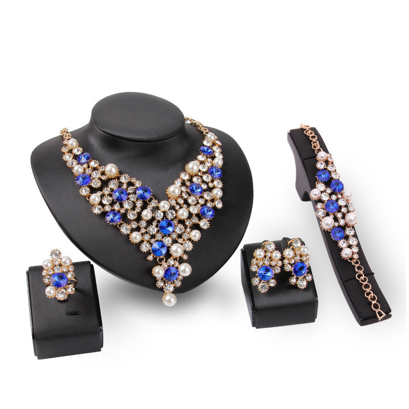 Jewelry set with necklace, earrings, and bracelet on black stands against a white background
