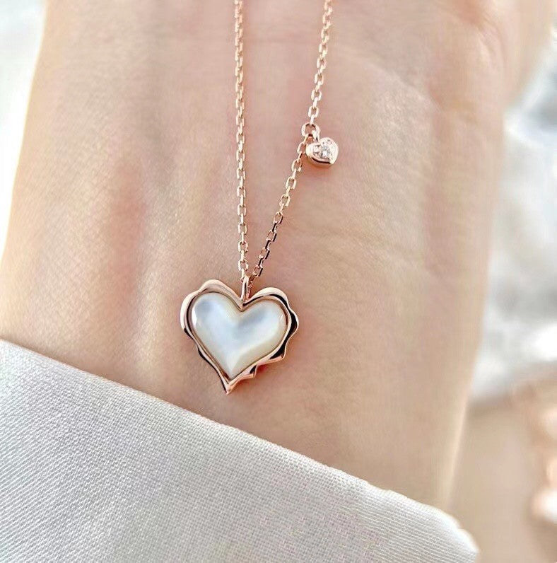 Heart-shaped pendant necklace with rose gold frame on a blurred background