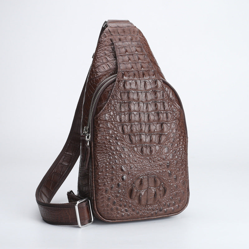 Brown crocodile-patterned sling bag on a light gray background