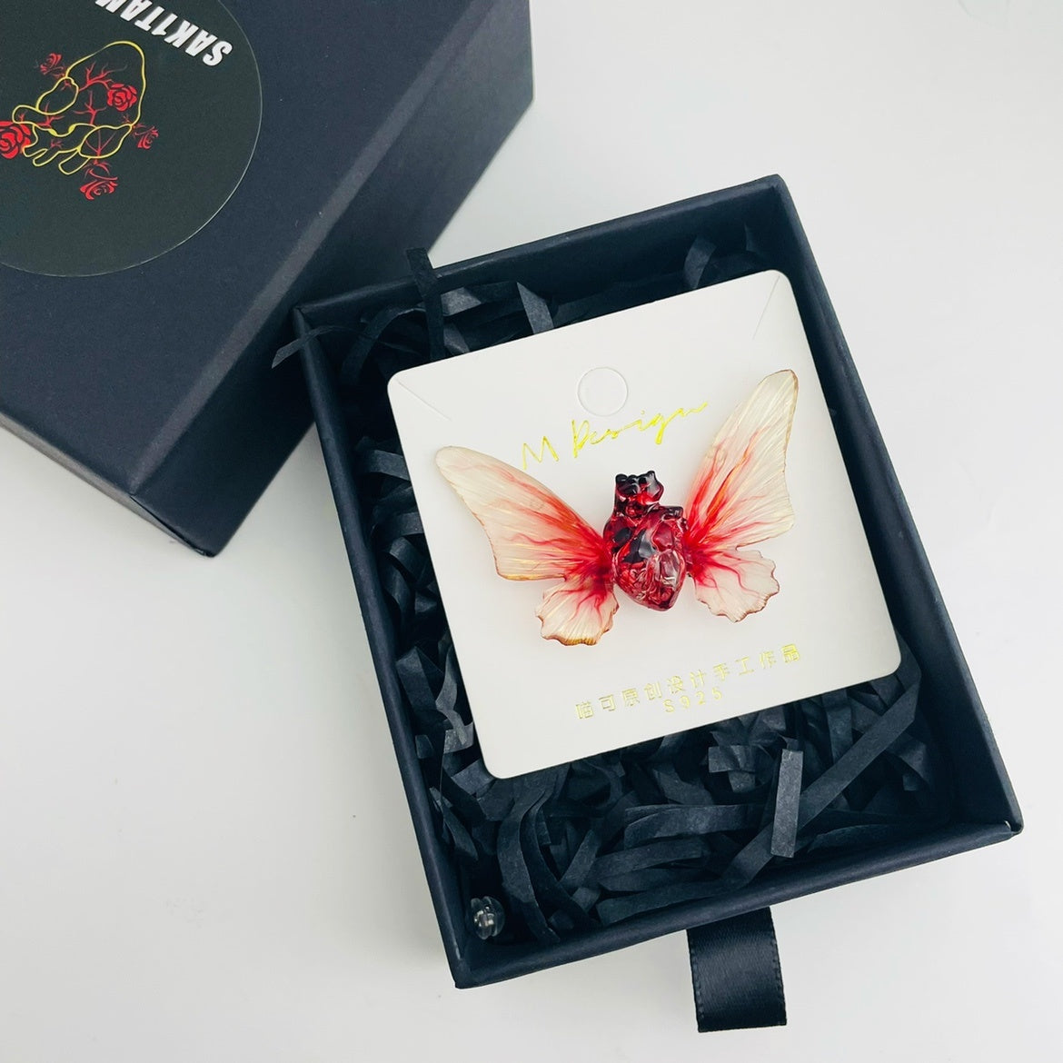 Butterfly-themed product inside a black gift box on a white background