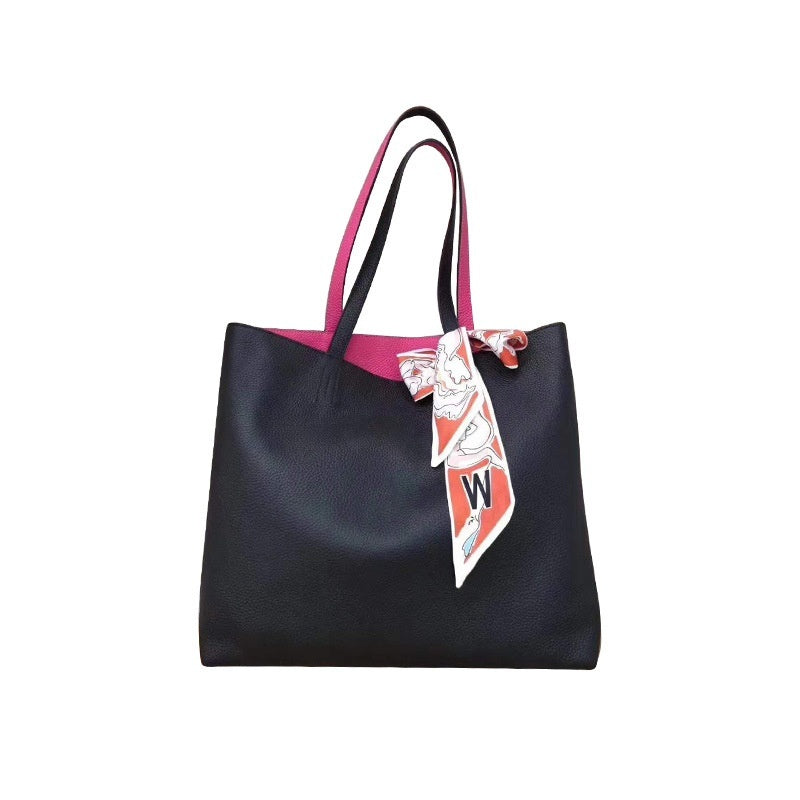 Black tote bag with pink interior and a decorative scarf on a white background