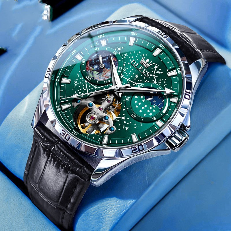 Luxury watch with green face and black leather strap on a blue background