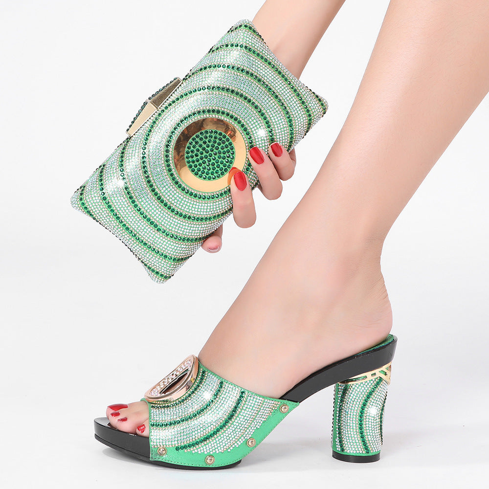 Green embellished shoes and clutch held by a person with red nail polish on a white background