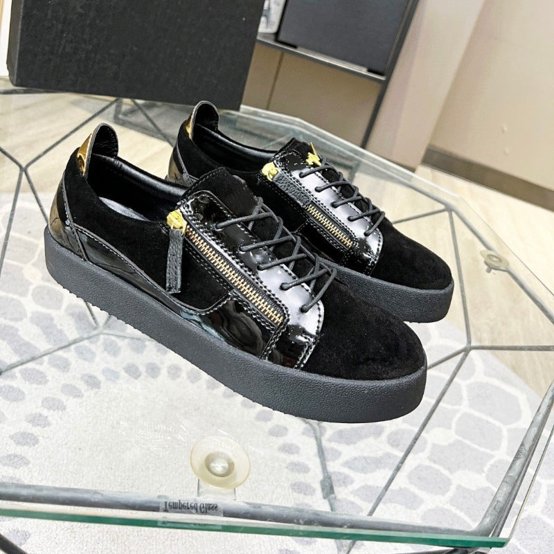 Black sneakers with gold zippers on a glass table