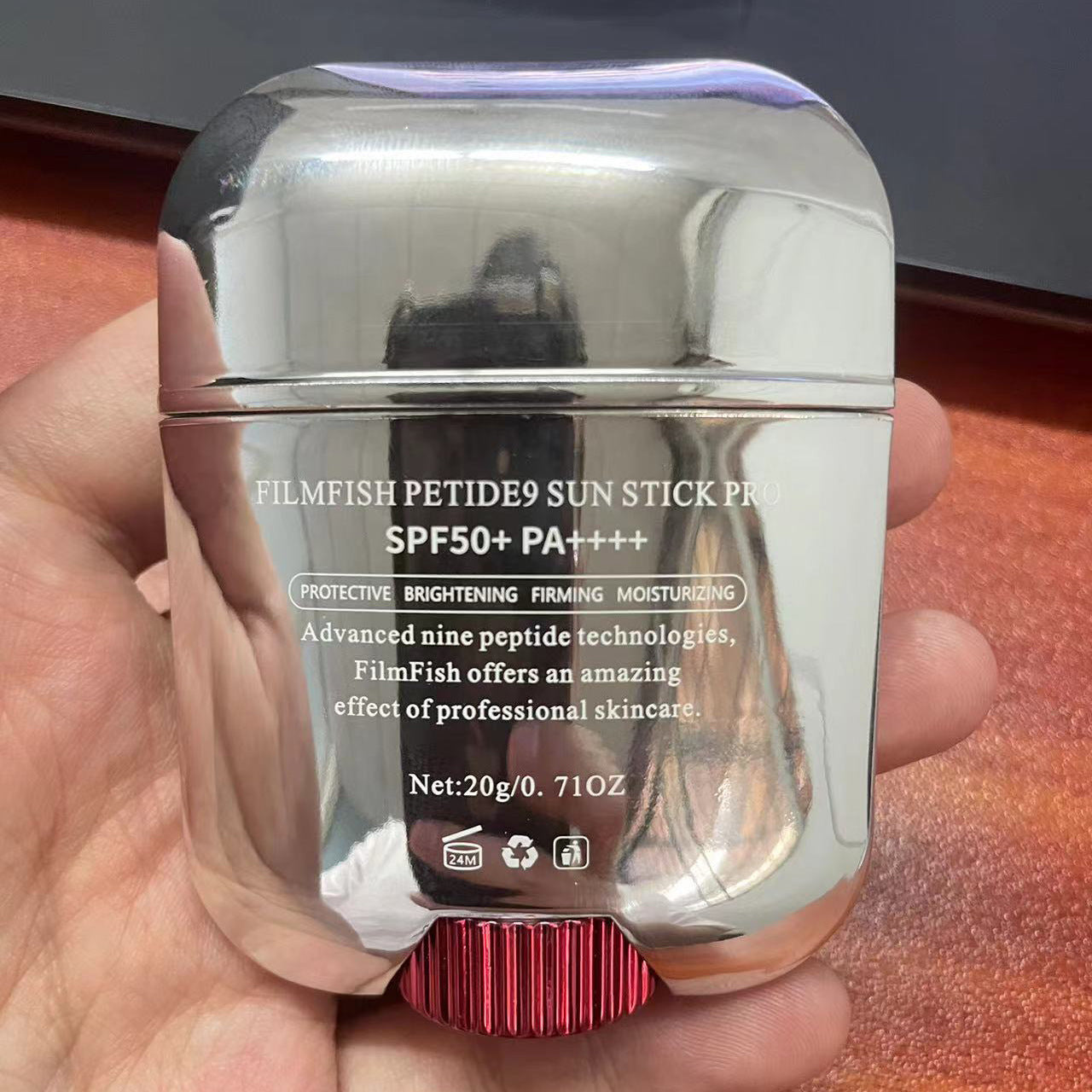 Silver sun stick packaging held in a hand with a blurred background